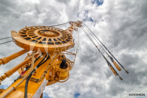 Picture of The boom of a drilling machine and a crane against the sky